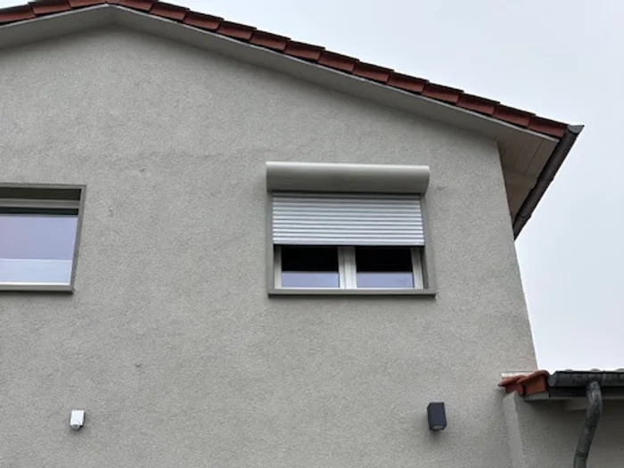 Zwei Fenster mit Aufsatz-Rollladenkästen an einer Giebelseite